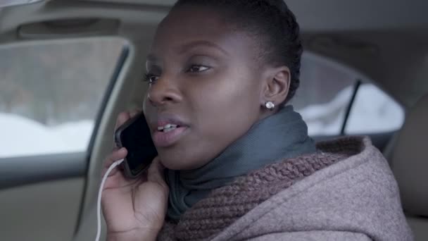 Portrait of self-confident african american woman sitting in the car close up talking by cell phone. Beautiful woman driving automobile — Stock Video