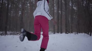 Sıcak giyen bir kırmızı şapka, eşarp ve beyaz ceket karlı ormanda çalışan korkmuş Afrikalı-Amerikalı genç kadın giyinmiş. Uzak takipçisi sürekli koşan kız arkasını döner