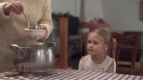 Abuela vierte sopa borscht a su pequeño cuenco nieta linda mientras ella está sentada y esperando — Vídeo de stock