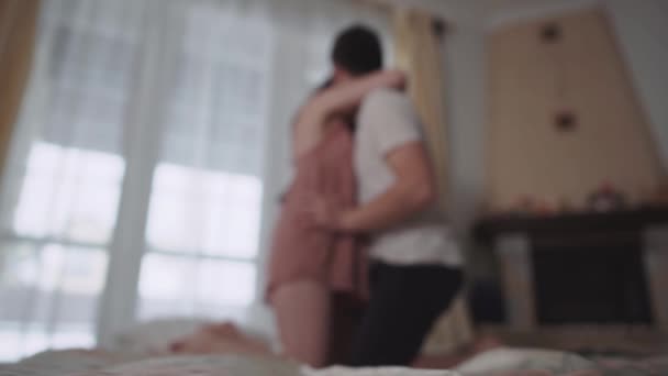 Silhouet man en vrouw zoenen op het bed op een onscherpe achtergrond. — Stockvideo