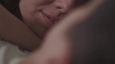 Genç womal yalan aşağı göğüs, gülümseme ve onun dilini göster. Genç aile eğlence. Genç bir çiftin ihale ilişki.