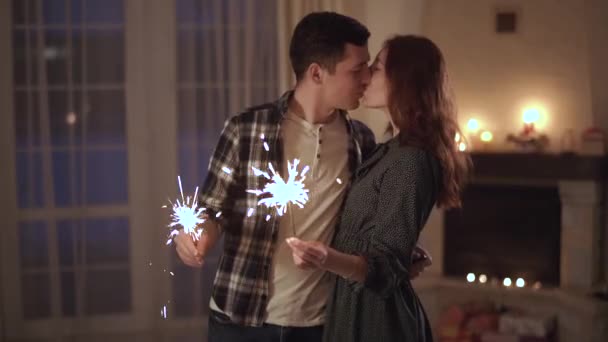 Heureux jeune couple debout avec des lumières du bengale dans les mains et les lèvres baisers. Relation tendre d'un jeune couple. Loisirs de la jeune famille . — Video