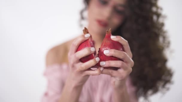 Portret van lachende grappige krullend meisje breken in twee delen sappige rijpe granaatappel. Slow motion — Stockvideo