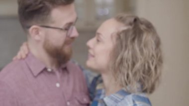 Bulanık şirin çift öpüşme portre kapatın. Mutlu genç ve kadın ile kamera kıvırcık saç seyir gösterir yüzük parmağında. Yeni evliler birlikte vakit