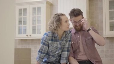Neşeli genç çift mutfak masasında evin düzenini tartışmaya yeni bir apartman dairesinde oturuyor. Yeni bir eve aile hamle.