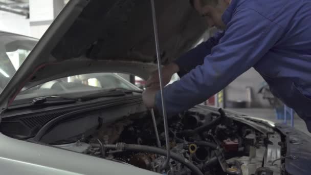 Service, reparatie, onderhoud en mensen concept auto - mechanic man aan het werk op workshop. Slow motion. — Stockvideo