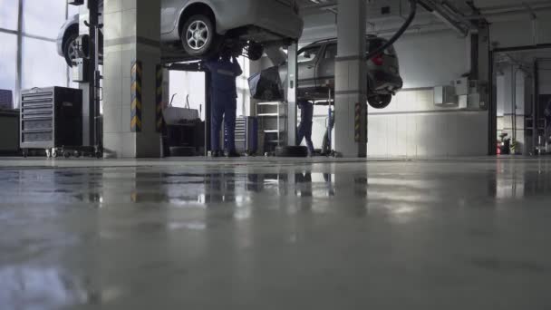 Taller de servicio de coche de seguridad pegado grande interior con equipos modernos en medio de un día de trabajo duro — Vídeo de stock