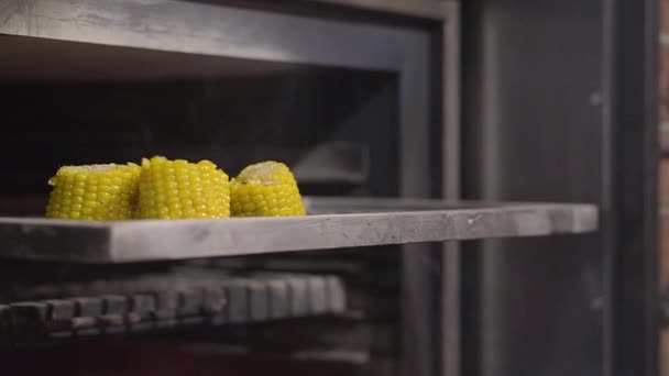 Nahaufnahme von geschnittenem Mais, der fertig zum Kochen auf dem Grill liegt. Zeitlupe. Zubereitung von Speisen in einem modernen Restaurant. — Stockvideo