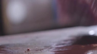 Şef bir kesme tahtası üzerinde bir iştah açıcı çiğ et parçası dönüm, bir et parçası boyunca bir bıçakla iletken ve kesim yapmak siyah aşçı eldiven eller yukarı kapatın