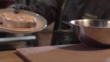 Siyah lateks eldiven koyar parça fırında somon Cook kapatın. Şef taze balık ızgara fırın yerleştirin. Bir restoranda yemek hazırlama