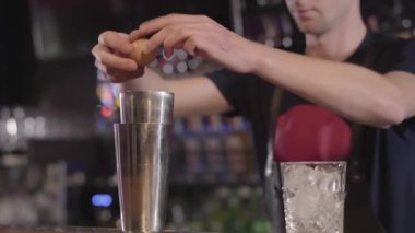 Genç barmen shaker ve sarısını beyazdan yakın çekim ayıran yumurta kırar. Adam figürü bulanık. Barmen sağlıklı kokteyl barda yapma