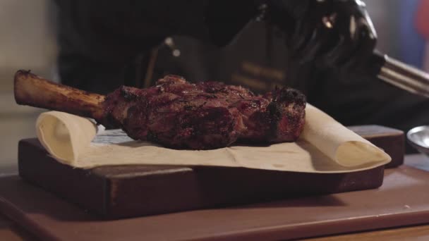 Close-up van chef-kok in zwarte fornuis handschoenen die dienst doen op een bord, gegrild vlees en gesneden stukjes geroosterde maïs. — Stockvideo
