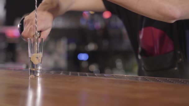 Unga bartendern hälla en uppfriskande sprit eller alkohol cocktail i ett litet glas. Närbild. — Stockvideo