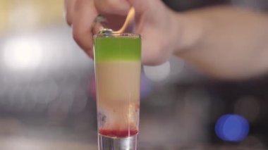 Yapmak için serinletici bir alkol kokteyl cam buz içine ateşe genç barmen göster. Yakın çekim.