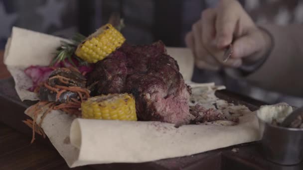 Uomo mangiare impressionante delizioso piatto con carne alla griglia e verdure seduti in ristorante di lusso. Da vicino. — Video Stock