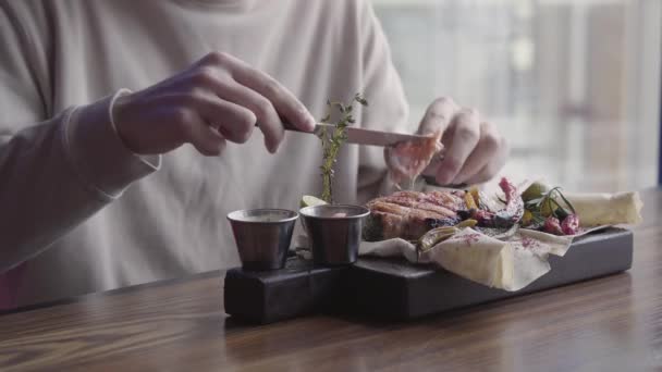 Detailní záběr muž eatting super chutné jídlo s grilovaným masem a zeleninou, sedět v luxusní restauraci. — Stock video