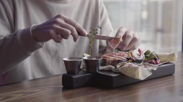 Close up homem comendo prato delicioso incrível com carne grelhada e legumes sentados em restaurante de luxo . — Vídeo de Stock