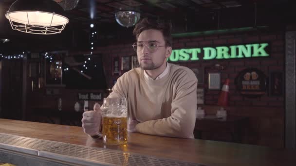 Красивый Молодой Человек Очках Счастливо Улыбающийся Пивая Пиво Пабе Смотря — стоковое видео