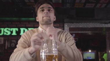 Bir futbol maçı iş günü sonra bar bar, içki bira ve saatler duygusal oturan ziyaretçi