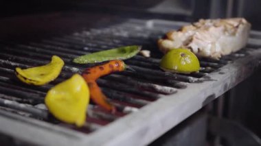 Şef elini koyar onları maşa kullanarak plaka üzerinde kapatın ve ızgara sebze tutuyor. Biber ve limon sulu et fırında parça ile pişirilir. Modern bir restoranda yemek hazırlama