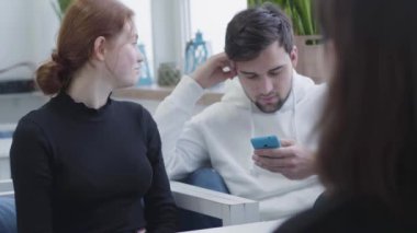 Bir kafe veya bir hub oturmuş, sohbet ve tatilinde, adam için emir bekliyoruz sms tipik süre gülümseyen üç arkadaş