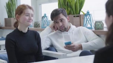 Bir kafe veya bir hub oturmuş, sohbet ve tatilinde, adam için emir bekliyoruz sms tipik süre gülümseyen üç arkadaş. Bir güzel rahat restoran veya Cafe gençlerin rahatla.