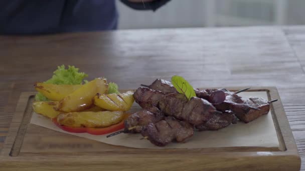 Szakács só és bors egy gyönyörűen felszolgált friss zöldségek, kövér burgonya és a kebab étel a pita kenyér — Stock videók