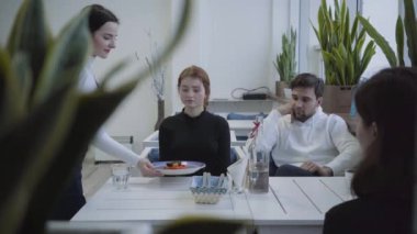 Arkadaşlar restoran ve gelen garson oturuyor ve gözlük ve bir şişe su ve iki tabak getirdi