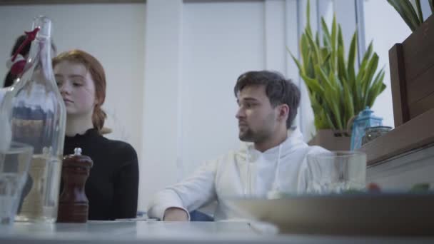 Les jeunes se reposent tout en déjeunant dans un restaurant ou un café confortable. Serveur venir et a apporté un plat savoureux pour un jeune homme . — Video