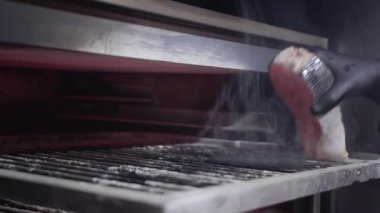Siyah eldiven balık somon ızgara charcoals ile fırın içine koyarak el