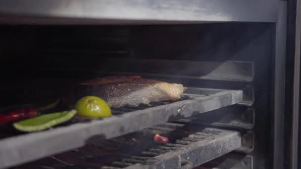 Uvnitř dřevěné uhlí pro grilování jsou vařené ryby losos, citron, paprikou a chilli — Stock video