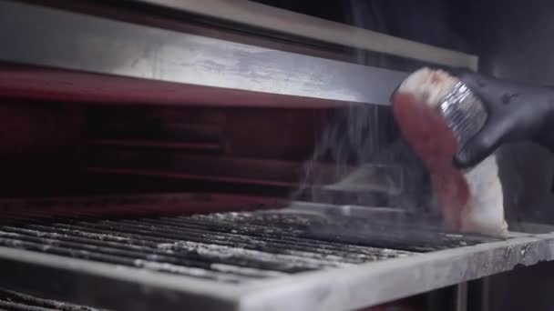 Kéz a fekete kesztyűt elhelyezés lazac hal belsejében a sütő Faszéngyártás, a grillezés — Stock videók