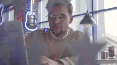 Gözlüklü genç yakışıklı adam oturup restoran ve laptop çalışma