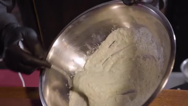 Šéfkuchař restaurace připravující chutné bílé omáčky. Ruce v černých rukavicích drží misku s bílou kapalinou. — Stock video