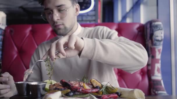 Hombre sentado en un restaurante de lujo y comiendo impresionante plato delicioso con carne a la parrilla y verduras — Vídeos de Stock