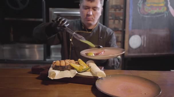 Chef em luvas pretas servindo em madeira acabou de cozinhar deliciosos peixes suculentos com pimentão grelhado, pimenta quente e limão. Fechar — Vídeo de Stock