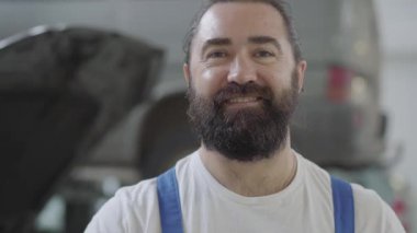 Portre yetişkin mekanik elini alnına losyonları. İşçi zor iş günü sonra yoruldu. Otomobil araba onarım istasyonu tespit üniformalı sakallı adam