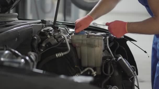 Mantenimiento provisional de automóviles en la estación de servicio. Servicio de coches, reparación, mantenimiento y concepto de personas - mecánico que trabaja en el taller — Vídeo de stock