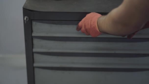 Zbliżenie dłoni mechanik w rękawice wyjąć narzędzie z pudełka. Mocowania samochodu pracownika w samochód naprawy stacji — Wideo stockowe