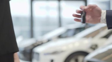 Tanınmayan satıcı iş takım elbiseli bir araba anahtarları tanınmayan başarılı işkadını ve shake elinde araba Bayilik verir. Araç Edilmesidir