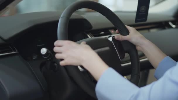 Žena dotýká volant s prsty zblízka. Moderní děvče zkoumání automobil v autosalonu. Koncepce na nákup automobilu, automobilový průmysl. Autosalonu. Předváděcí — Stock video