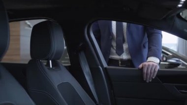 Tanınmayan işadamı takım ayakta modern Bayilik arabaya yakın. Kendine güvenen adam Otomobil araba showroom incelenmesi. Otomatik satın alma kavramı.