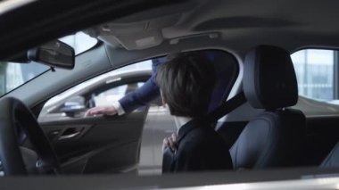 Güzel genç kız kısa saç kesimi ile yeni otomatik yolcu bölmesi araba Showroom yeni arabanın içinde otururken inceliyor. Başarılı güzel kadın yeni otomatik inceliyor. Araba Bayilik.