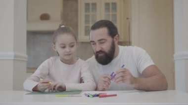 Genç Baba ve küçük şirin kızı oturma odasında ve işaretleri ile yeşil karton üzerinde çizim