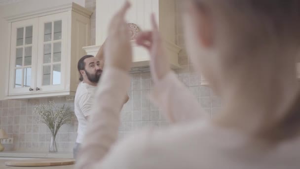 Fille dire à son père où il est préférable de placer une plaque décorative sur le capot dans une nouvelle cuisine moderne — Video