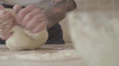 Yakın çekim yakışıklı genç pizza Maker Tekdüzen yoğurma hamur pizza evde modern mutfak pişirin. Yiyecek hazırlama kavramı