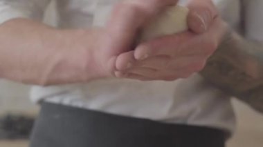 Eller genç pizza Maker modern mutfakta pizza hamur topları yuvarlanma aşçı üniformalı kapatın. Gıda hazırlama kavramı