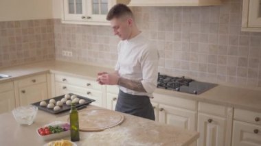 Pizza makinesi tepsisi mutfak pişirme pizza hamur topları koymak aşçı üniformalı. Gıda hazırlama kavramı. Yukarıdan çekim Üstten Görünüm