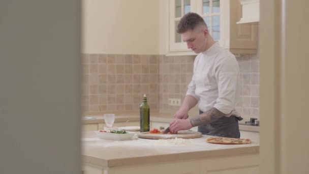 Επαγγελματική cook σε ομοιόμορφο περικοπές ντομάτες σε μια μόνιμη ξύλινη σανίδα στην κουζίνα στο σπίτι. Μαγειρική έννοια. — Αρχείο Βίντεο