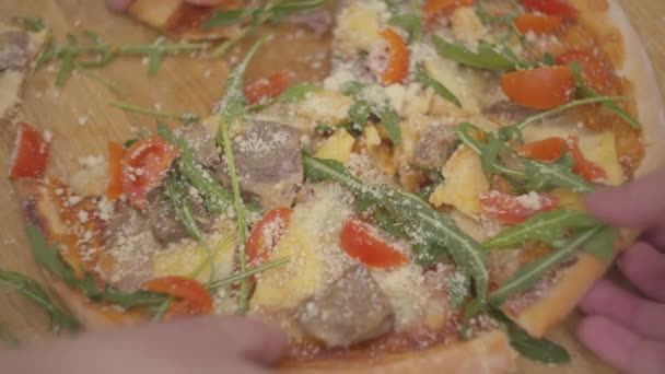 Primer plano de deliciosa pizza apetitosa que se encuentra en una tabla de madera. Manos de diferentes personas toman un pedazo de pizza . — Vídeos de Stock